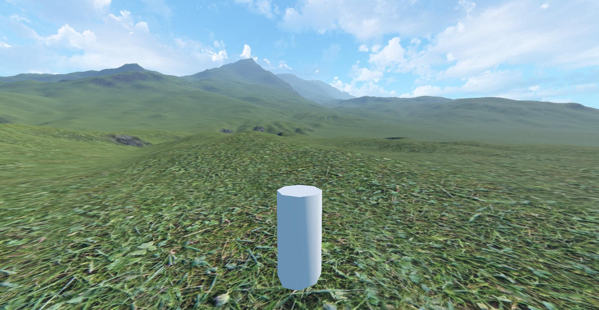 Screen capture of a landcape textured with grass and rocks, with distant mountains fading in a light haze, under a blue sky with a few white clouds. The viewpoint is at ground level, behind a white cylinder that represents the player character.